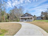 Charming home features a welcoming front porch and a long driveway at 12300 Caldwell Rd, Charlotte, NC 28213