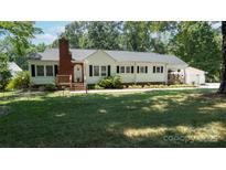Charming one-story home with brick chimney and manicured front yard in a peaceful, wooded setting at 1327 Mount Ulla Hwy, Mooresville, NC 28115