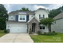Charming two-story home featuring a stone entryway, attached garage, and well-manicured front lawn with landscaping at 14505 Rhodes Hall Dr, Charlotte, NC 28273