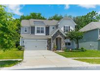 Charming two-story home featuring a stone entrance, a two-car garage and verdant landscaping at 14505 Rhodes Hall Dr, Charlotte, NC 28273