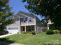 Charming two-story home boasts a well-manicured lawn and attached garage at 1818 Windy Willow Ln, Dallas, NC 28034