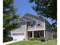 Charming two-story home featuring a well-manicured lawn, attached garage, and inviting covered porch perfect for relaxation at 1818 Windy Willow Ln, Dallas, NC 28034
