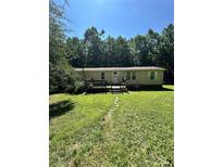 Ranch home featuring a small front porch, manicured lawn, and lush landscaping at 194 Wild Plum Ln, Blacksburg, SC 29702