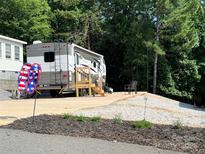 Charming RV parked on a well-maintained lot with landscaped gravel, offering a serene getaway at 207 Cardinal Dr, New London, NC 28127