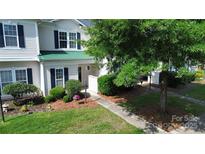 Charming townhome featuring a well-manicured lawn and tasteful landscaping, complete with a welcoming front walkway at 4151 Town Center Rd, Harrisburg, NC 28075