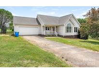 Charming single-story home features a well-maintained lawn, attached garage, and a classic covered front porch at 7006 Lone Eagle Dr # 18, Monroe, NC 28110