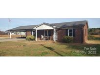 Charming brick home with a quaint front porch and carport offers curb appeal at 711 Burtonwood Ln, Lincolnton, NC 28092