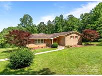 Charming brick home featuring a well-maintained lawn and mature trees, creating a picturesque curb appeal at 885 Roy Cline Rd, Rockwell, NC 28138