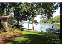 Lakefront backyard with a lush lawn, mature trees and a private dock for enjoying waterfront living at 114 Caraway Ln, Mooresville, NC 28117