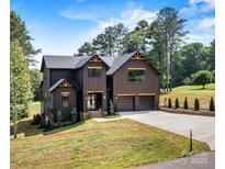 Striking two-story home with a modern design, dark exterior, three gables, and a well-manicured lawn at 130 Broken Arrow Dr, Statesville, NC 28677
