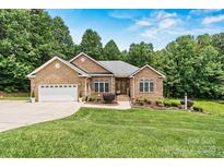Charming brick home with a well-manicured lawn and inviting curb appeal nestled in a wooded lot at 1616 Indian Springs Nw Dr, Conover, NC 28613