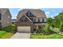 Beautiful two-story home featuring a brick facade, attached garage, and well-manicured lawn at 17637 Snug Harbor Rd, Charlotte, NC 28278