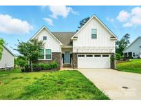 Charming two-story home with stone accents, a well-manicured lawn, and an attached two-car garage at 18619 Mainsail Ct, Lancaster, SC 29720