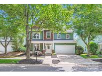 Charming two-story home with green siding, wood accents, and a well-maintained front yard at 18732 Coachmans Trce, Cornelius, NC 28031