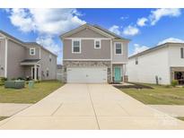 Charming two-story home with stone accents, attached garage, and a welcoming turquoise front door at 2116 Morgan Hills Dr, Albemarle, NC 28001