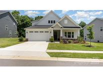 Charming single-Gathering home featuring a two-car garage, manicured lawn, and welcoming front porch at 218 Tetcott St, Mooresville, NC 28115