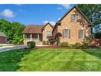 Charming brick home with lush front lawn and manicured landscaping at 3831 Riceland Pl, Charlotte, NC 28216