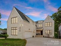Elegant two-story home featuring white brick, black trim windows, and a well-manicured lawn at 408 Ideal Way, Charlotte, NC 28203