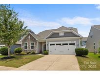 Charming single-Gathering home with stone accents, a two-car garage, and manicured lawn at 5059 Fenwick Ct, Lancaster, SC 29720