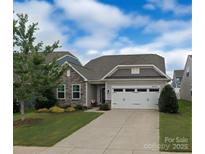 Charming single Gathering home featuring stone accents, a two-car garage, and manicured landscaping at 5059 Fenwick Ct, Lancaster, SC 29720