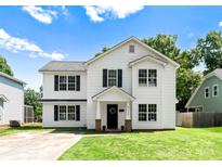 Charming two-story home features a classic white exterior and well-manicured lawn at 5229 Tarrywood Ln, Charlotte, NC 28205