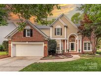 Charming two-story brick home with tan siding, manicured lawn, and inviting front entrance at 5707 Fairvista Dr, Charlotte, NC 28269