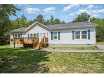 Charming single story home featuring a covered deck and beautiful landscaping at 5720 Enochville School Rd, Kannapolis, NC 28081