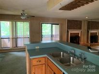 Eat-in kitchen featuring a double sink, ample cabinet space, and connection to an adjacent room at 5727 Dockside Dr, Charlotte, NC 28227