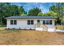 Charming single-story home with a freshly painted white exterior and a welcoming light blue front door at 756 Logan St, Mooresville, NC 28115