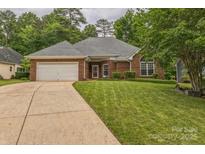 Charming single-story brick home featuring an attached two-car garage and well-maintained front lawn at 9137 Brightleaf Pl, Charlotte, NC 28269