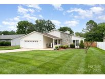 Charming home featuring stone accents, an attached garage, and a well-manicured lawn at 9319 Chislehurst Rd, Mint Hill, NC 28227