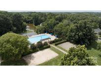 An aerial view of a pool, volleyball court, basketball court and other community features at 1003 Snake River Ct, Monroe, NC 28110