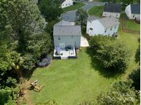 Aerial view of a spacious backyard with a deck, trampoline, and lush green lawn at 1003 Snake River Ct, Monroe, NC 28110