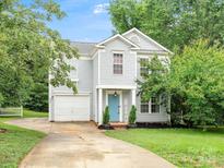 Charming two-story home featuring light blue siding, a blue front door, and a well-maintained front yard at 1003 Snake River Ct, Monroe, NC 28110