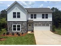 Charming two-story home with stone accents, white siding, attached garage, and a well-manicured lawn at 10339 Lakeshore Dr # 85, Lancaster, SC 29720