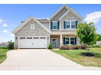 Beautiful two-story home with stone accents, blue shutters, landscaped yard, and a two-car garage at 106 Tuppy Ct, Statesville, NC 28625