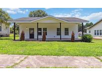 Charming white bungalow featuring a covered porch, dark-framed windows, and a lush green lawn at 113 Woodside Ave, Gastonia, NC 28054