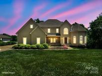 Charming two-story home at dusk with landscaped yard and warm, inviting lighting at 122 Long Cove Ln, Mooresville, NC 28117