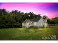 Charming single-Gathering home with a spacious lawn and a welcoming front porch, bathed in the glow of a vibrant sunset at 132 Witherspoon Ln, Statesville, NC 28677