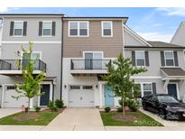Charming townhome featuring a balcony, attached garage, and manicured lawn, showcasing a modern design at 15034 Scoter St, Charlotte, NC 28262