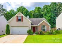 Charming home featuring a well-manicured lawn, attached garage, and a mix of brick and siding exterior at 1520 Deer Forest Dr, Fort Mill, SC 29707