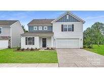 Charming two-story home featuring a modern exterior, landscaped yard, and a two-car garage at 1547 Cottage Creek Dr, Bessemer City, NC 28016
