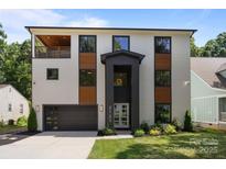Modern two-story home featuring a stylish facade, balcony, and well-manicured landscaping at 2121 Laburnum Ave, Charlotte, NC 28205