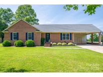 Single-story brick home with well-kept lawn, classic shutters, and a convenient covered carport at 233 Reliance Rd, Kings Mountain, NC 28086