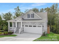 Charming home with stone accents, a welcoming porch, and a two-car garage at 24578 Blue Heron Cir # 407, Lancaster, SC 29720