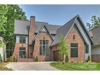 Charming brick home features a well-manicured lawn and an attached garage at 2921 Windsor Ave, Charlotte, NC 28209
