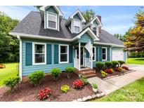 Charming two-story home featuring a well-maintained lawn, colorful flowerbeds, and inviting front porch at 328 Pamela St, Gastonia, NC 28054