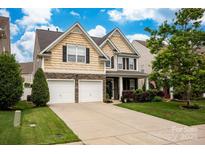 Charming two-story home features a landscaped front yard, two-car garage, and inviting curb appeal at 3351 Streamside Dr, Davidson, NC 28036