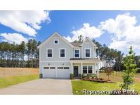 Charming two-story home featuring a two-car garage, a well-manicured lawn, and a welcoming front porch at 36140 Greg Norman Dr # 1003, Lancaster, SC 29720