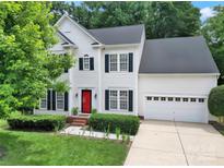 Charming two-story home boasts a well-manicured lawn, black shutters, and a vibrant red front door at 488 Saint George Rd, Fort Mill, SC 29708